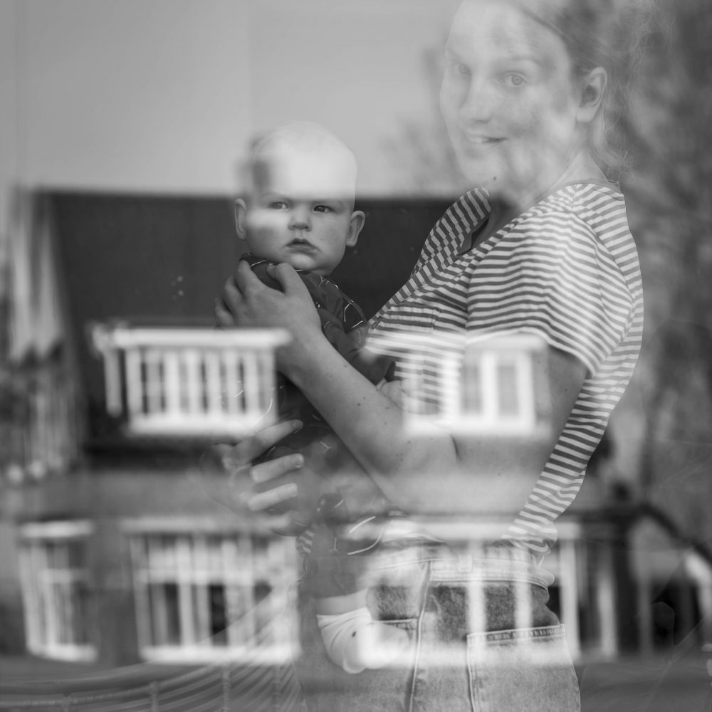 baby-met-moeder-achter-raam-spiegeling-coroanaportret-jemooisteherinnering-fotografie