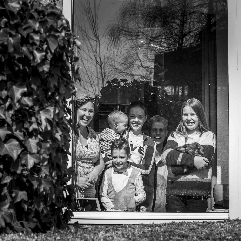 gezin-lachend-achter-raam-met-konijn-jemooisteherinnering-fotografie
